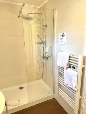 a bathroom with a shower with a glass door at Hotel La Citadelle in Villefranche-sur-Mer