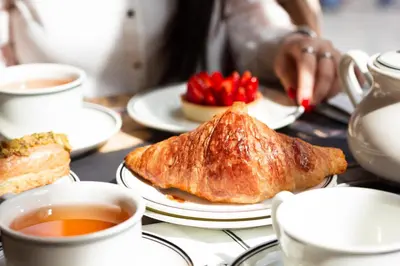 a table with plates of food and cups of tea at Hotel La Citadelle in Villefranche-sur-Mer