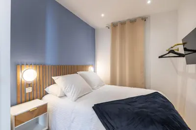 a bedroom with a white bed and a blue wall at Design Apartment near the Beaches of Nice in Nice