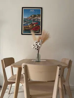 a wooden table with a vase of flowers on it at Bel appartement au calme hyper centre Nice in Nice