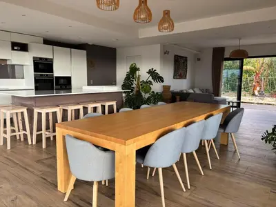 a kitchen and living room with a wooden table and chairs at Luxury villa piscine chauffée confort exceptionnel in Nice