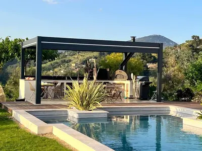 a pavilion with a swimming pool in a backyard with a table and a table at Luxury villa piscine chauffée confort exceptionnel in Nice