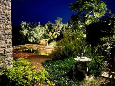 a garden at night with a pond and a bridge at Luxury villa piscine chauffée confort exceptionnel in Nice