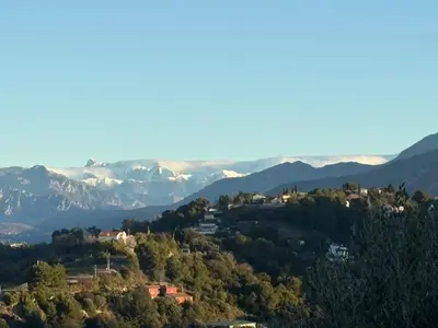 a town on a hill with mountains in the background at Luxury villa piscine chauffée confort exceptionnel in Nice