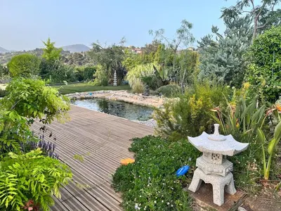 a garden with a stone altar and a pond at Luxury villa piscine chauffée confort exceptionnel in Nice