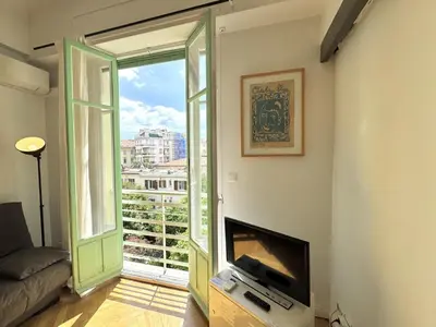 a living room with a television and a large window at B G La Residence Grimaldi Promenade des Anglais in Nice