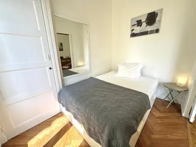 a small bedroom with a bed and a mirror at B G La Residence Grimaldi Promenade des Anglais in Nice