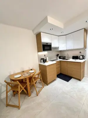 a kitchen with a table and two chairs and a table at Appartement Nice Magnan promenade in Nice