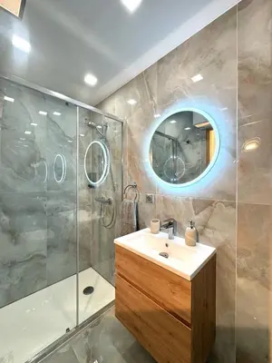 a bathroom with a sink and a shower and a mirror at Appartement Nice Magnan promenade in Nice