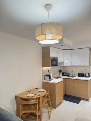 a kitchen with a wooden table and a dining room at Appartement Nice Magnan promenade in Nice