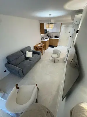 a living room with a couch and a kitchen at Appartement Nice Magnan promenade in Nice