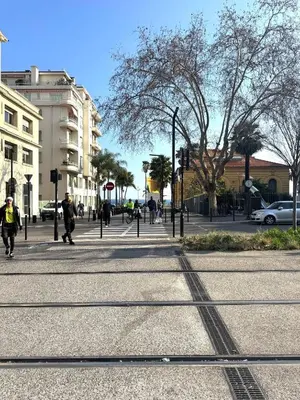 a group of people walking down a city street at Appartement Nice Magnan promenade in Nice