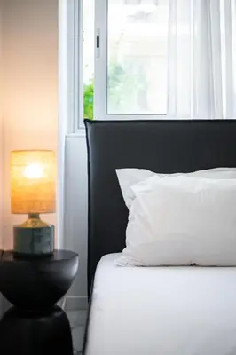 a bed with a lamp on a table next to a window at Nice - Mordern Apartment Sea Close in Nice