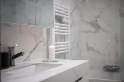 a white candle sitting on a counter in a bathroom at Nice - Mordern Apartment Sea Close in Nice
