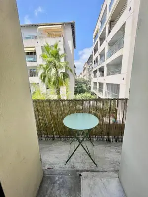 a green table in a courtyard with buildings at Nice two-rooms with balcony in Nice in Nice