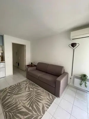 a living room with a couch and a floor lamp at Cœur de Nice in Nice