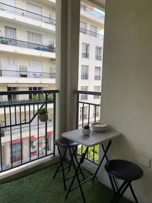a table and two chairs in a room with two windows at Cœur de Nice in Nice