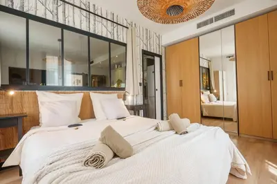a bedroom with a large white bed with large windows at Magnifique Appartement 3P in Nice