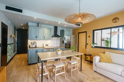 a kitchen and living room with a table and a couch at Magnifique Appartement 3P in Nice
