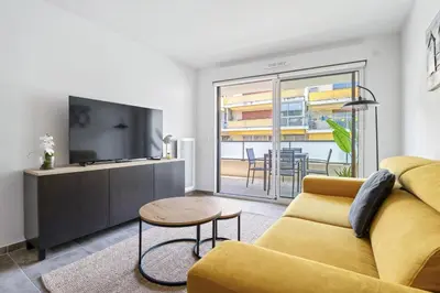 a living room with a yellow couch and a tv at Appartement Amandiers - Welkeys in Cagnes-sur-Mer