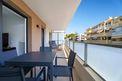 a balcony with tables and chairs on a building at Appartement Amandiers - Welkeys in Cagnes-sur-Mer