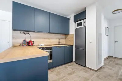 a kitchen with blue cabinets and a counter top at Appartement Amandiers - Welkeys in Cagnes-sur-Mer