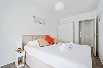 a bedroom with a white bed with towels on it at Appartement Amandiers - Welkeys in Cagnes-sur-Mer