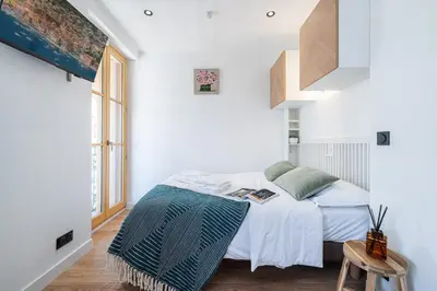 a bedroom with a bed with white walls and a window at MY CASA - BUFFA 3-53 - Superb Studio Suite City Center in Nice