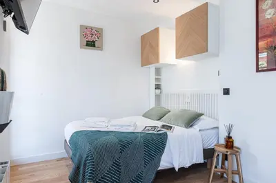 a bedroom with a bed with white sheets and green pillows at MY CASA - BUFFA 3-53 - Superb Studio Suite City Center in Nice