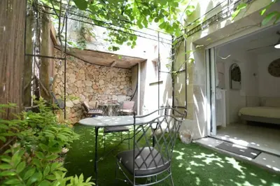 a patio with a table and chairs in a garden at Unique havre de paix in Nice