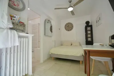 a bedroom with a bed and a table and a clock at Unique havre de paix in Nice
