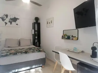 a bedroom with a desk and a bed and a desk and a table and chairs at Unique havre de paix in Nice