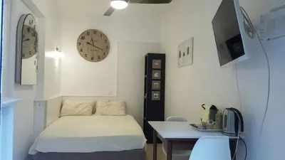a bedroom with a bed and a desk and clocks at Unique havre de paix in Nice