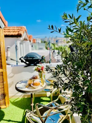 a table with a plate of food on a balcony at Nice - Little Studio with Sunny Terrace in Nice