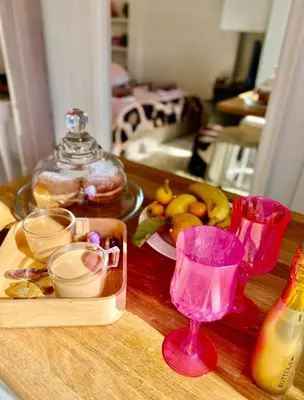 a table with a tray of food and a pink glass at Nice - Little Studio with Sunny Terrace in Nice