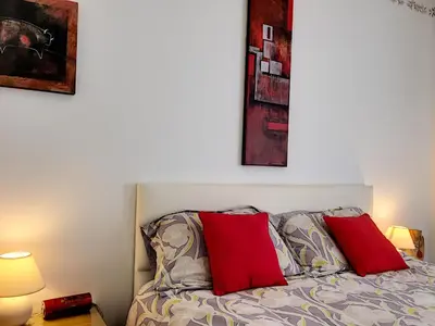 a bedroom with a bed with two red pillows at Nestor&Jeeves - VILLA HARMONIE TERRASSE - Central - Free parking in Nice
