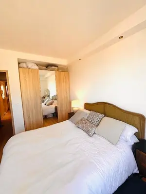 a bedroom with a white bed with two pillows at Les Floralies - Beaulieu-sur-Mer in Beaulieu-sur-Mer
