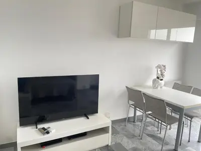 a living room with a tv and a table with chairs at STUDIO EN FACE DE LA PLAGE AVEC une VUE FANTASTIQUE ! in Nice