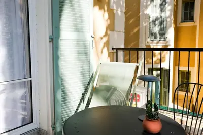 a table on a balcony next to a window at Casa Luna in Nice