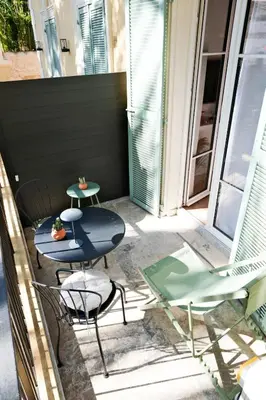 a patio with two tables and chairs on a balcony at Casa Luna in Nice
