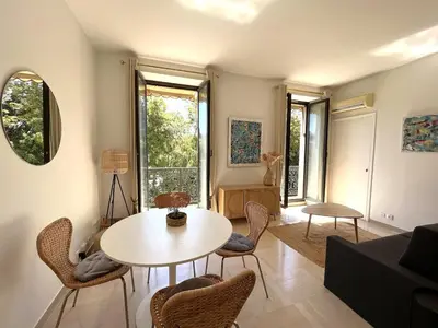 a living room with a table and chairs at Beautiful studio with parking place Massena in Nice
