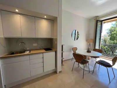 a kitchen with a sink and a table with chairs at Beautiful studio with parking place Massena in Nice