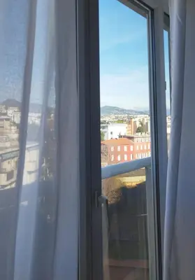 an open window with a view of a city at Appartement cosy sur la French Riviera I Climatisation I 2 minutes des plages in Nice