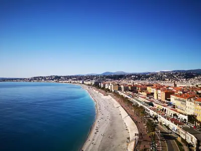 a view of a beach with buildings and the ocean at Appartement cosy sur la French Riviera I Climatisation I 2 minutes des plages in Nice