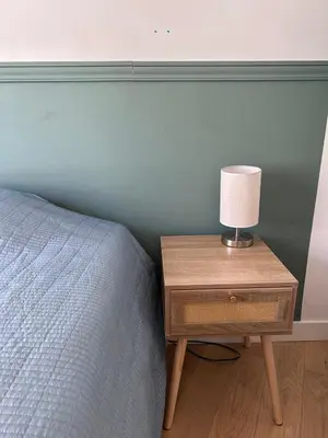a bed with a nightstand with a lamp on it at Shared flat in Liberation in Nice