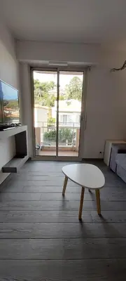 a living room with a table and a large window at Studio Cosy proche Carlone, balcon in Nice