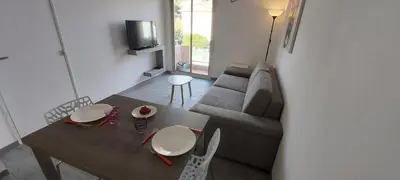 a living room with a couch and a table at Studio Cosy proche Carlone, balcon in Nice