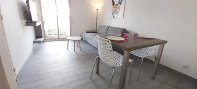 a living room with a table and a couch at Studio Cosy proche Carlone, balcon in Nice
