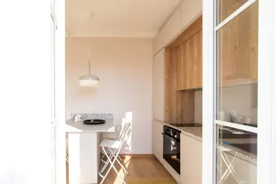 a kitchen with white walls and wooden cabinets at #25 2BDR Port, 5min from the Old Town Balcony, AC&WIFI in Nice