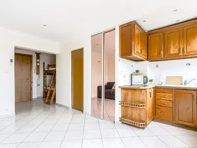 an empty kitchen with wooden cabinets and a room at Apartment Le Mirazur by Interhome in Nice